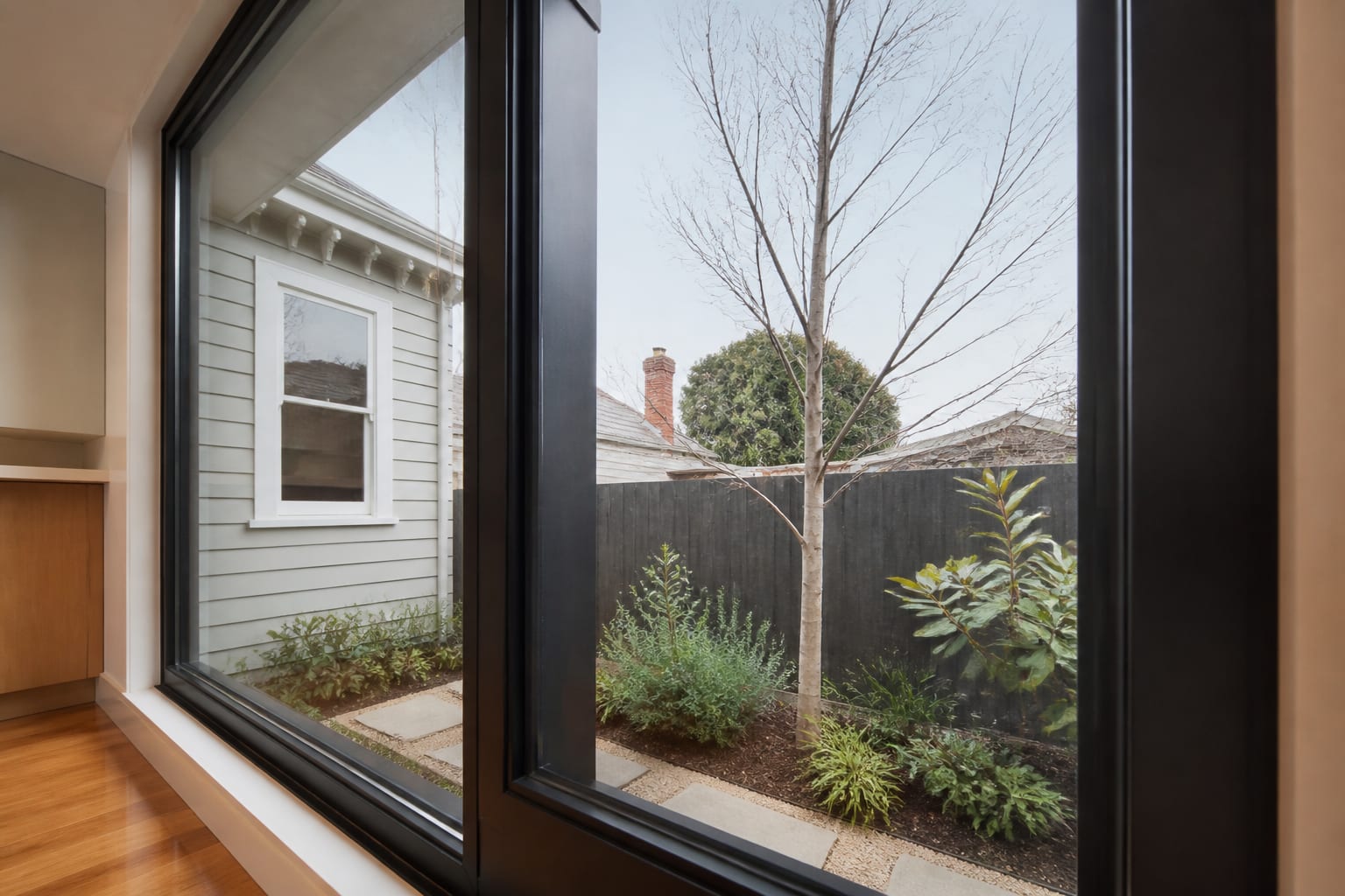 Aluminium double-glazed window in a Melbourne home, condensation-free inner pane looking onto a winter garden